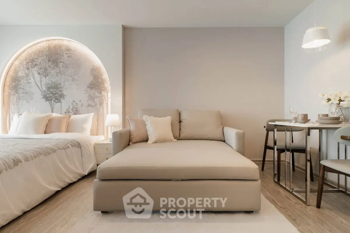 Elegant studio apartment with cozy bed, stylish sofa, and chic dining area.