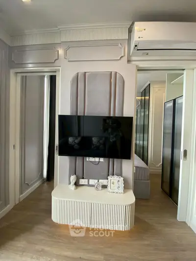 Modern living room with sleek TV setup and elegant decor in a stylish apartment.