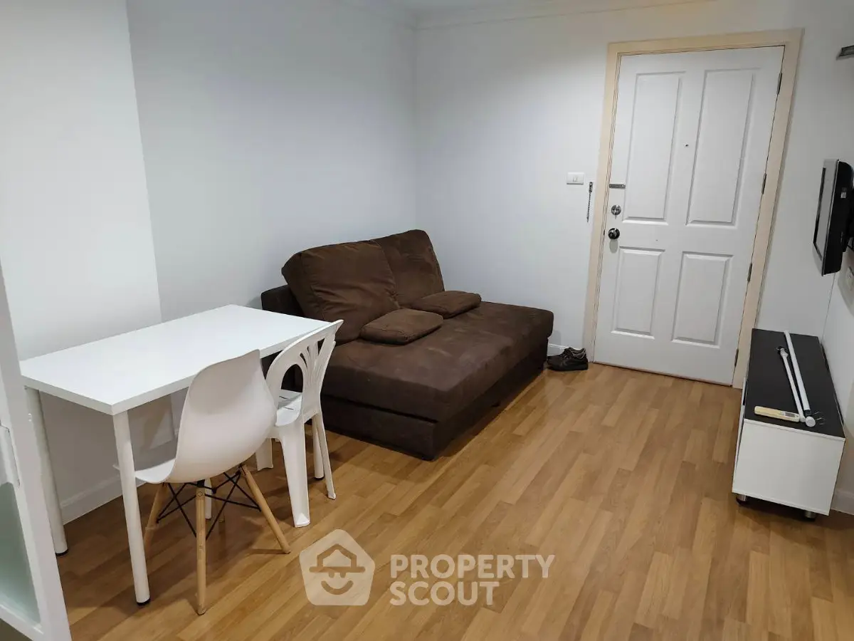 Cozy living room with brown sofa and dining table, perfect for small apartments.