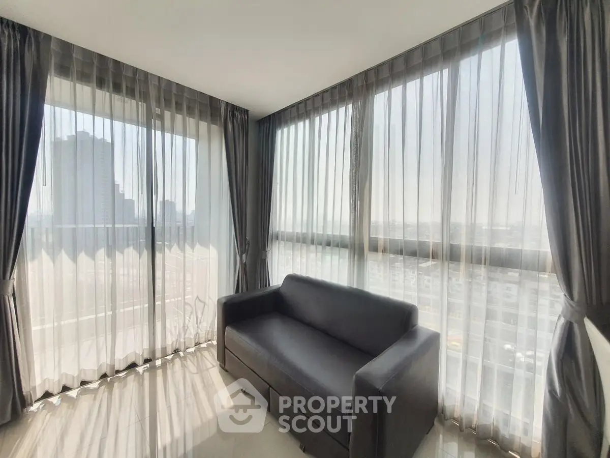 Spacious corner unit living room with panoramic city views and elegant curtains.