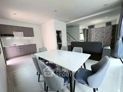 Modern open-plan living and dining area with sleek kitchen and stylish furniture.