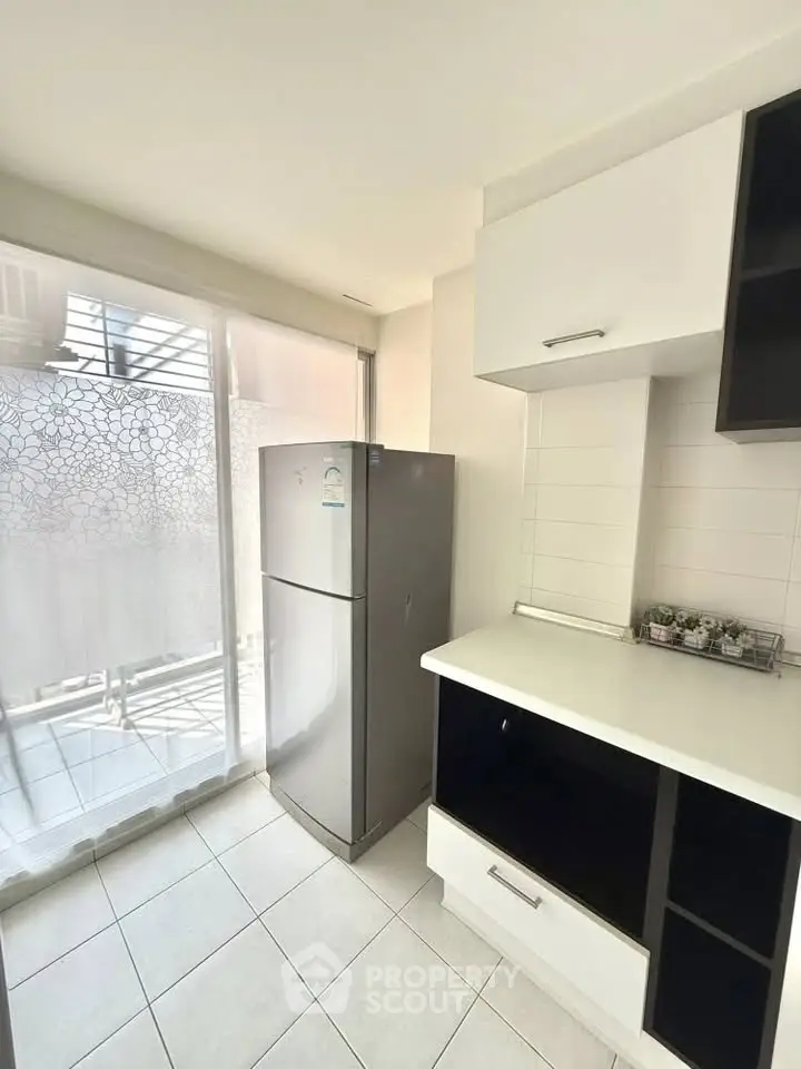 Modern kitchen with sleek fridge and ample natural light