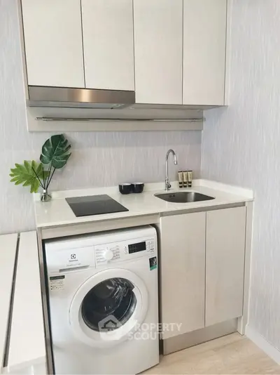 Modern compact kitchen with washing machine and sleek cabinetry