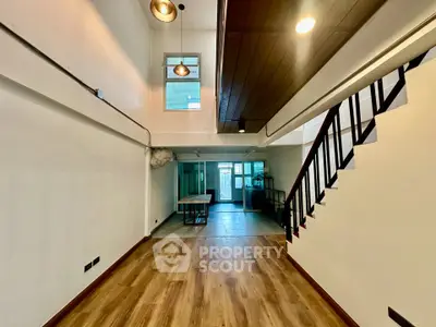 Spacious modern interior with high ceilings and wooden flooring, perfect for stylish living.