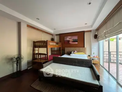 Spacious bedroom with bunk bed and large window opening to a balcony, perfect for family living.