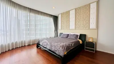 Luxurious bedroom with elegant decor and floor-to-ceiling windows offering stunning city views.