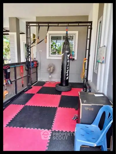 Spacious home gym with punching bag and equipment, perfect for fitness enthusiasts.