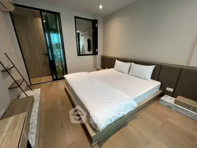 Modern bedroom with sleek design and wooden flooring in a stylish apartment.