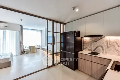 Modern open-layout kitchen with sleek appliances and stylish living area in luxury apartment.