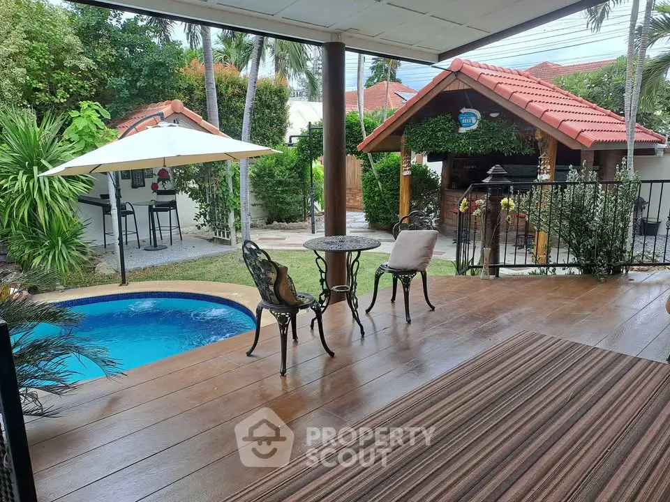 Charming backyard with pool, patio seating, and lush greenery for perfect outdoor relaxation.