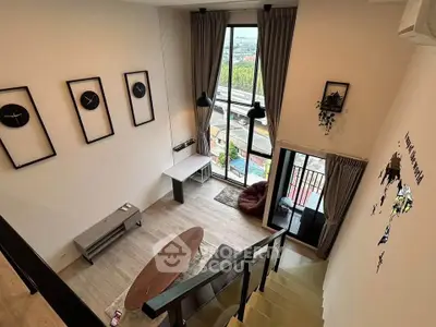 Modern loft-style living room with high ceilings and large windows offering stunning views.