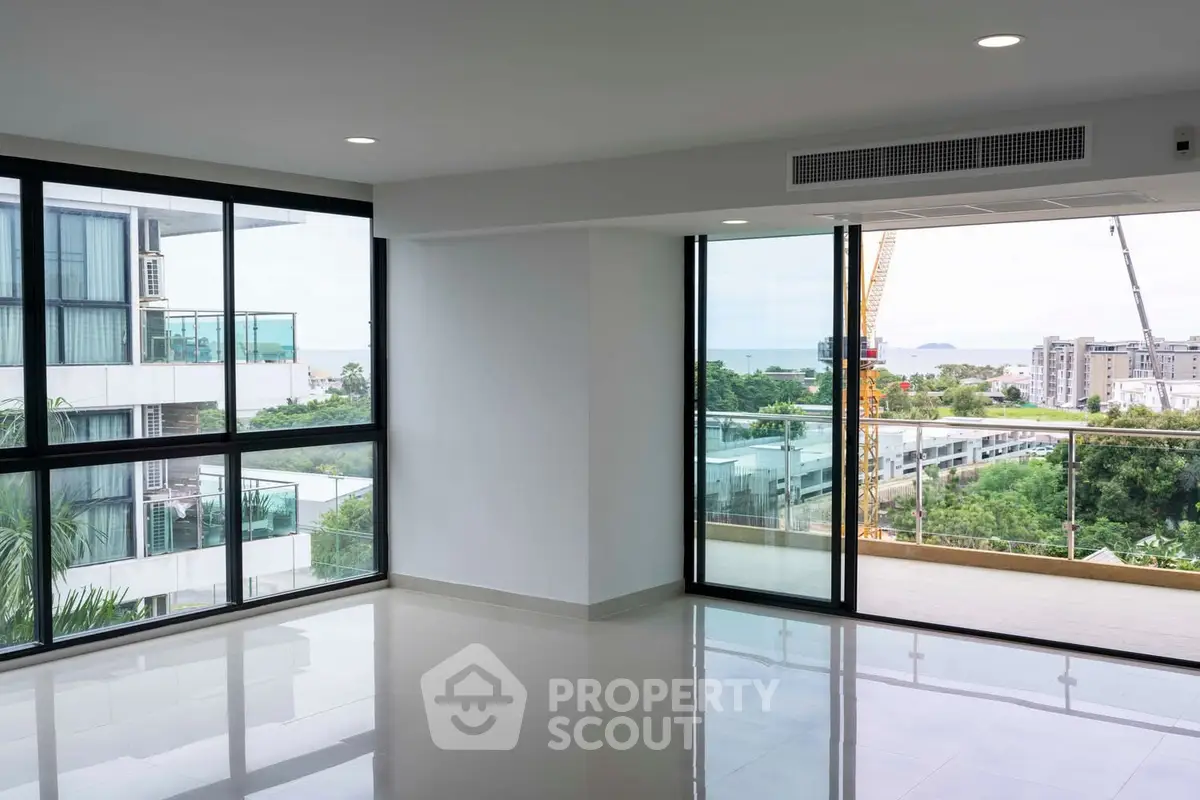 Spacious modern living room with large windows and balcony view