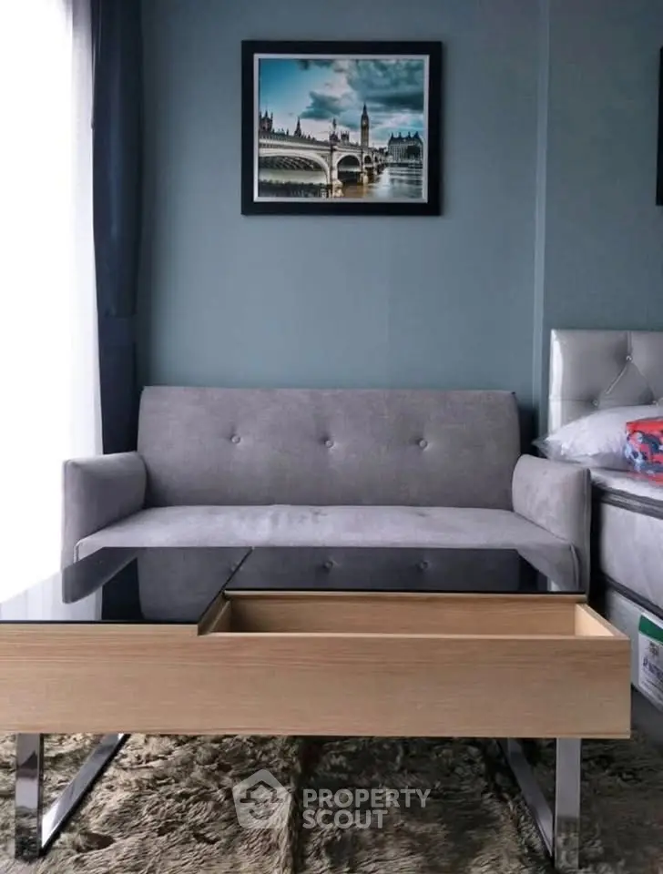 Stylish living room with modern sofa and sleek glass-top coffee table in cozy apartment.