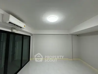 Spacious empty room with modern air conditioning and sliding glass doors, perfect for customization.