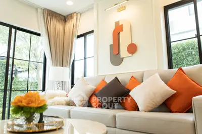 Stylish living room with modern decor and vibrant cushions, perfect for relaxation.