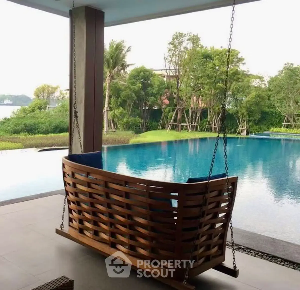 Luxurious poolside view with elegant wooden swing and lush greenery, perfect for relaxation and leisure.