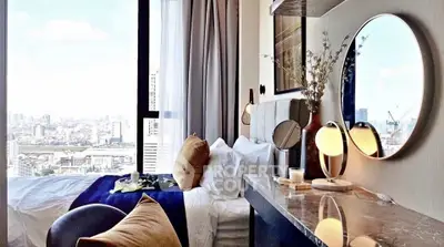 Luxurious bedroom with stunning city view, elegant decor, and modern furnishings in high-rise apartment.