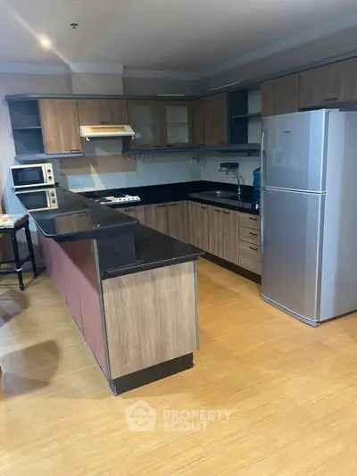 Spacious kitchen with modern appliances and sleek wooden cabinetry in a stylish home.
