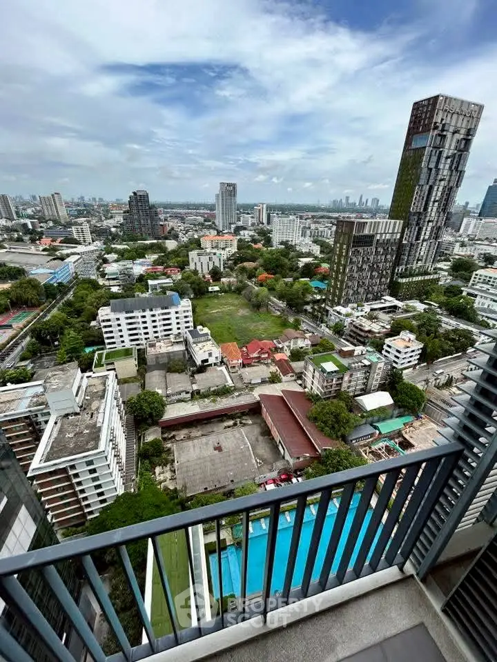 Stunning cityscape view from high-rise balcony overlooking urban skyline and lush greenery.