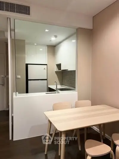 Modern kitchen with open layout and dining area in a stylish apartment.