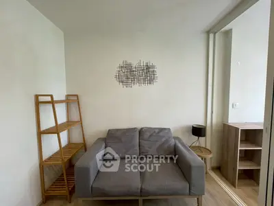 Modern living room with stylish gray sofa and wooden shelving unit, perfect for cozy relaxation.