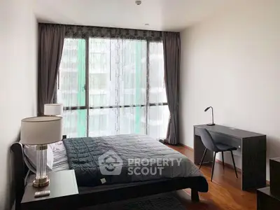 Modern bedroom with large window and stylish furnishings in a high-rise apartment.