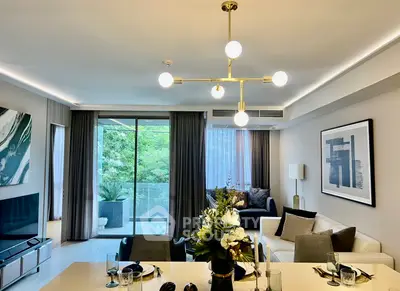 Modern living room with elegant decor and large windows opening to a lush balcony view.