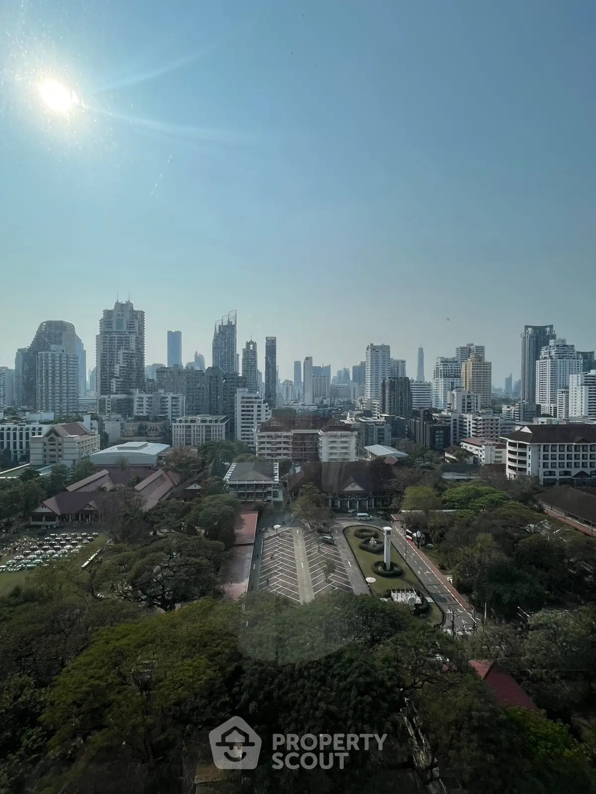 Stunning cityscape view from high-rise building with lush greenery and skyline