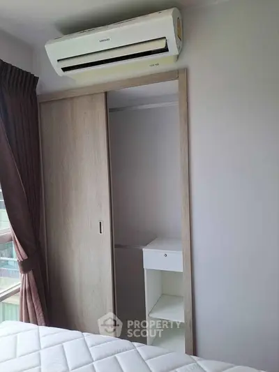 Cozy bedroom with built-in closet and air conditioning unit, perfect for comfortable living.