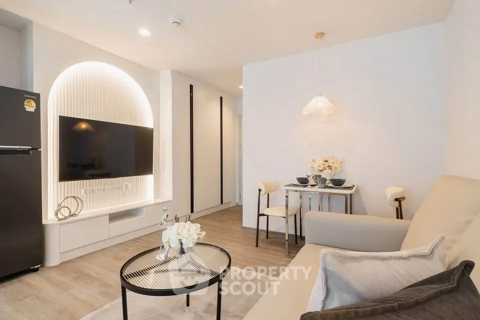 Modern living room with sleek furniture, wall-mounted TV, and stylish lighting in a cozy apartment.