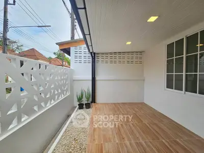 Modern covered patio with wooden flooring and decorative wall