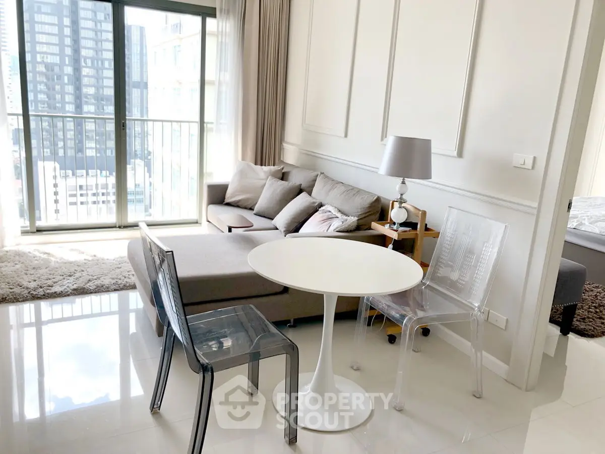 Modern living room with city view, featuring sleek furniture and natural light.