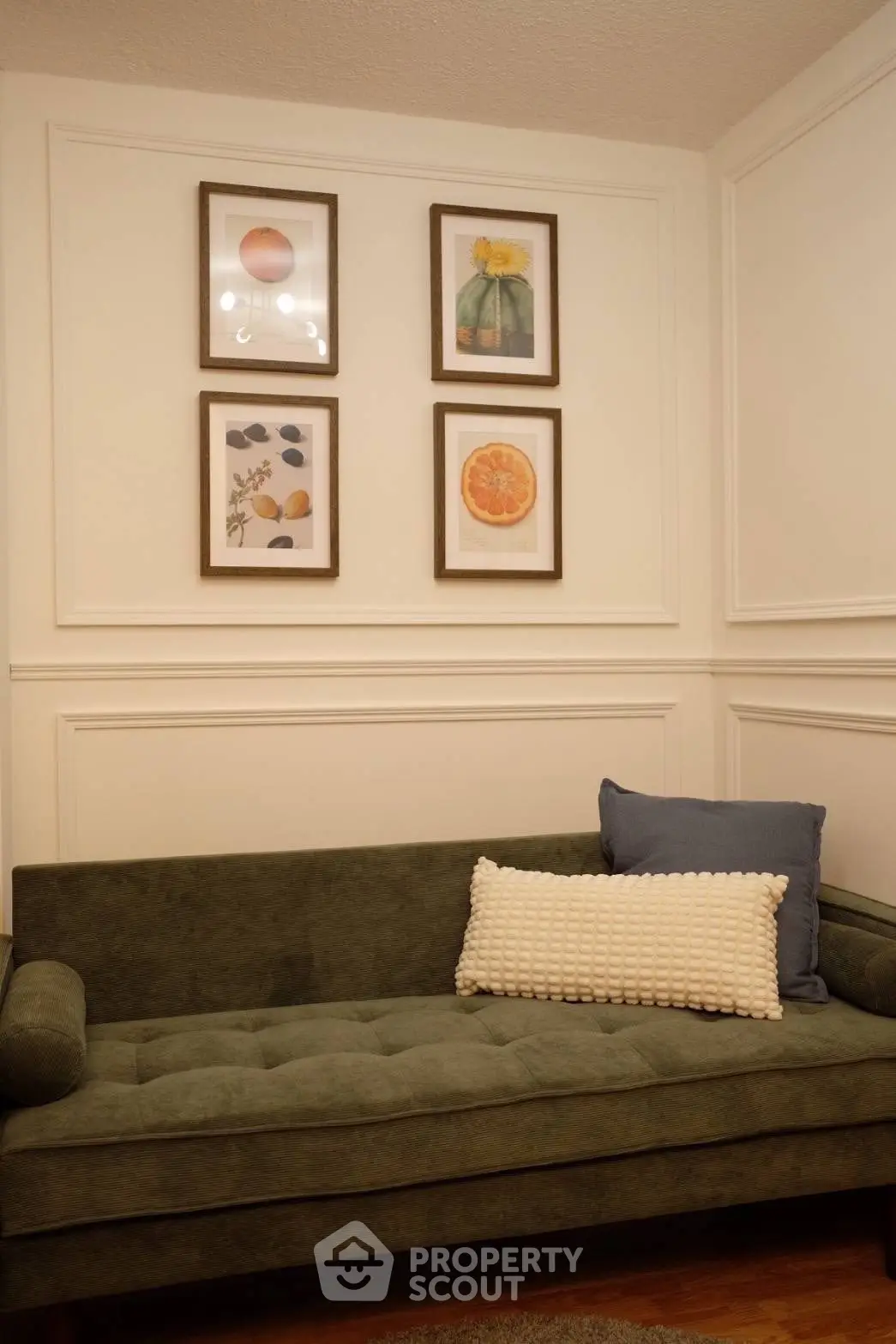 Cozy living room with stylish green sofa and framed art on wall.
