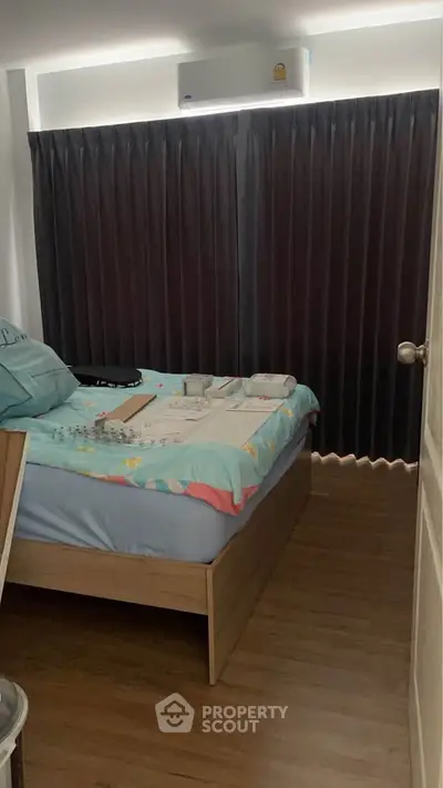 Cozy bedroom with modern air conditioning and dark curtains, perfect for restful nights.