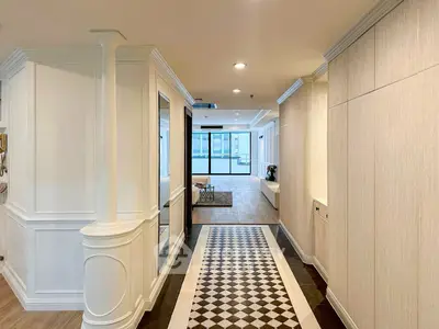 Elegant hallway with checkered floor leading to a bright living area with large windows.