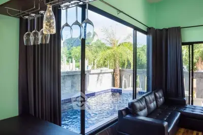Luxurious living room with pool view and modern decor, perfect for relaxation and entertaining.