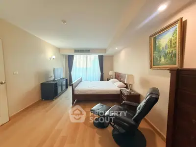 Spacious bedroom with elegant decor and natural light in a modern apartment.