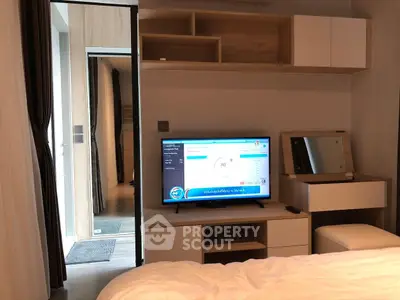 Modern bedroom with sleek TV setup and stylish furniture, perfect for contemporary living.