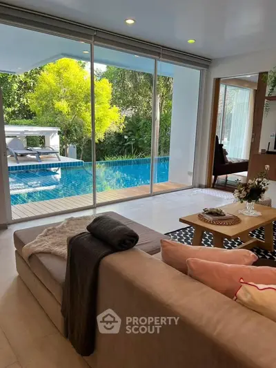 Luxurious living room with pool view and modern decor, perfect for relaxation and entertaining.