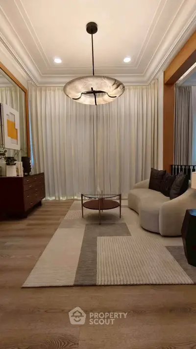 Elegant living room with modern chandelier, cozy sofa, and stylish decor, perfect for contemporary living.