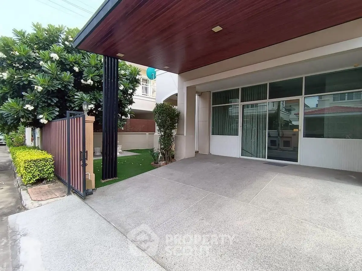 Modern home entrance with spacious driveway and lush greenery