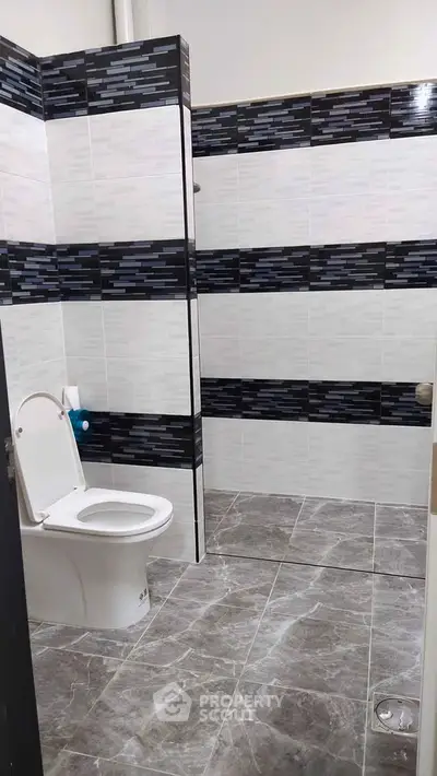 Modern bathroom with stylish black and white tile design and sleek fixtures.