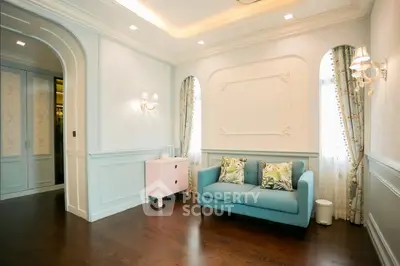 Elegant living room with classic decor, featuring a blue sofa and stylish wall sconces.