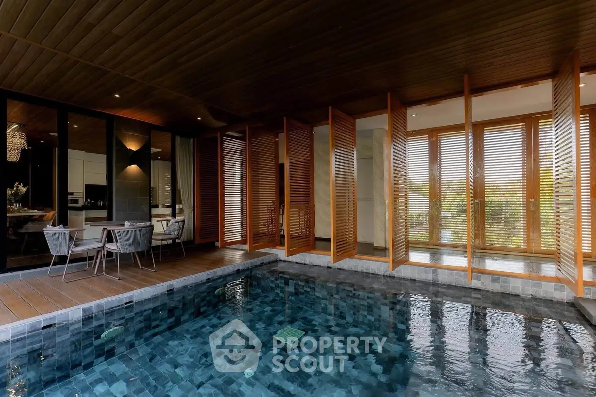 Luxurious indoor pool area with wooden accents and modern design, perfect for relaxation and entertainment.