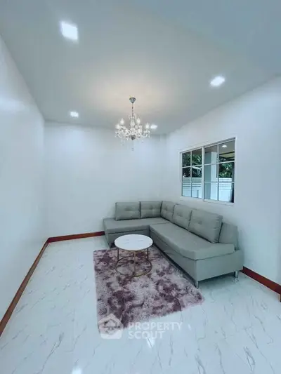 Elegant living room with modern chandelier and stylish L-shaped sofa