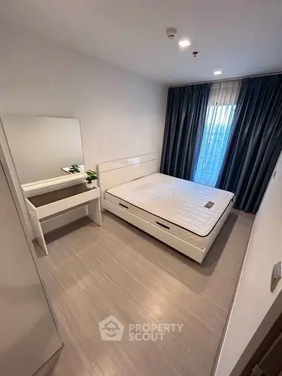 Modern minimalist bedroom with large window and sleek furnishings.