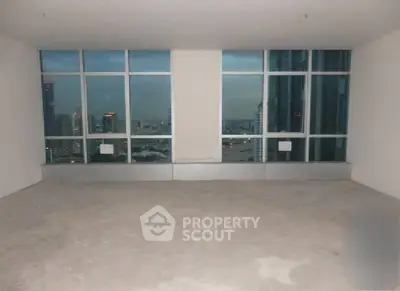 Spacious empty room with large windows offering stunning cityscape views.