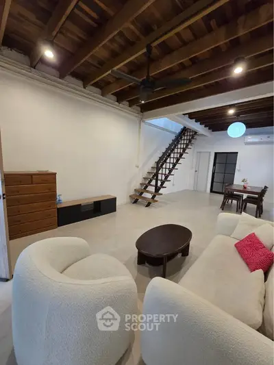 Spacious living room with modern furniture and wooden ceiling beams