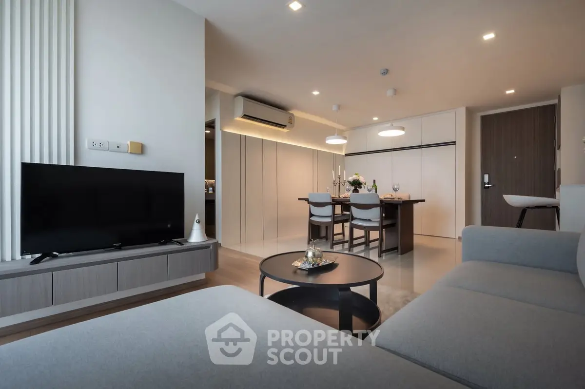 Modern living room with sleek furniture and open dining area in a stylish apartment.