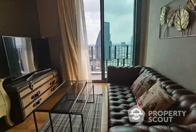 Chic urban living room with plush leather sofa, modern entertainment unit, and floor-to-ceiling windows leading to a breezy balcony with city views.